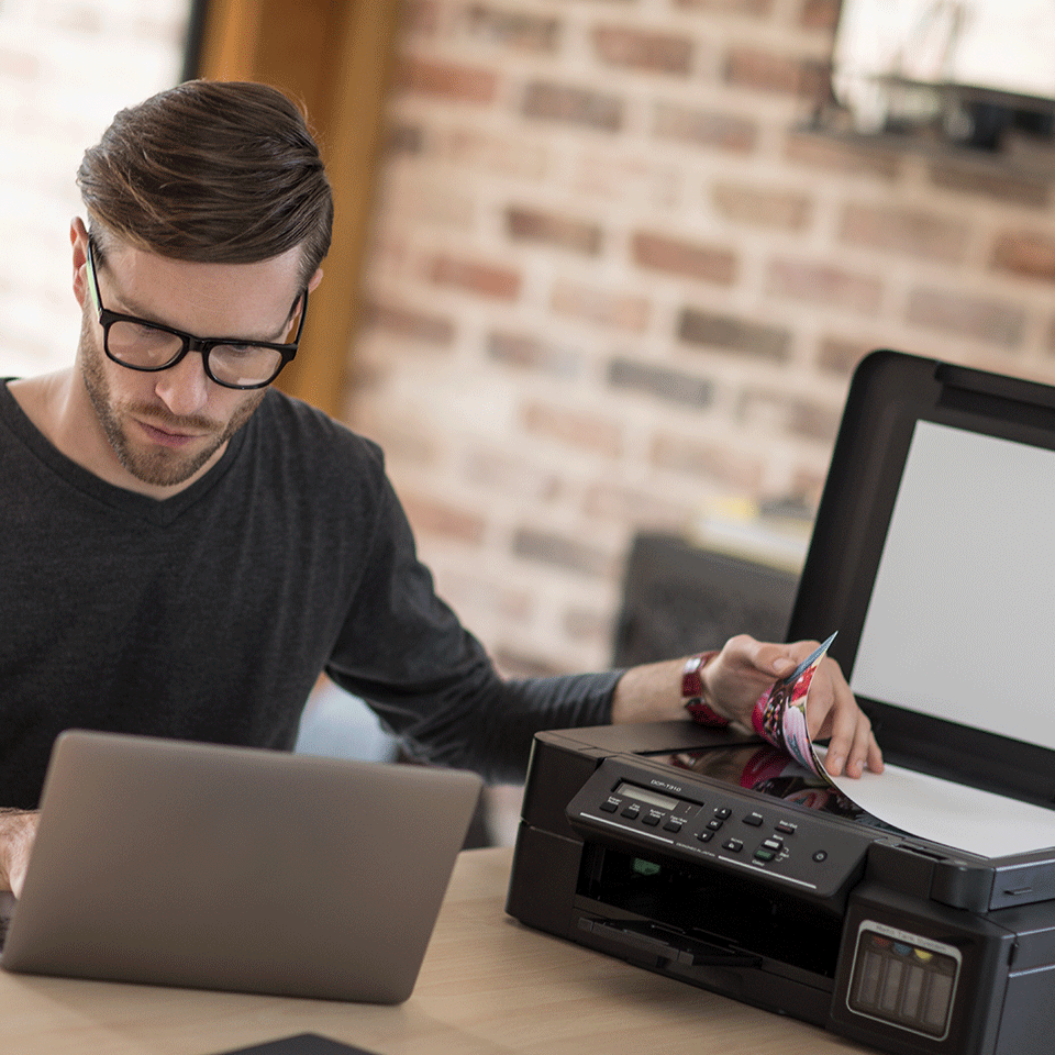 Man interacting with DCPT310 black inkjet printer