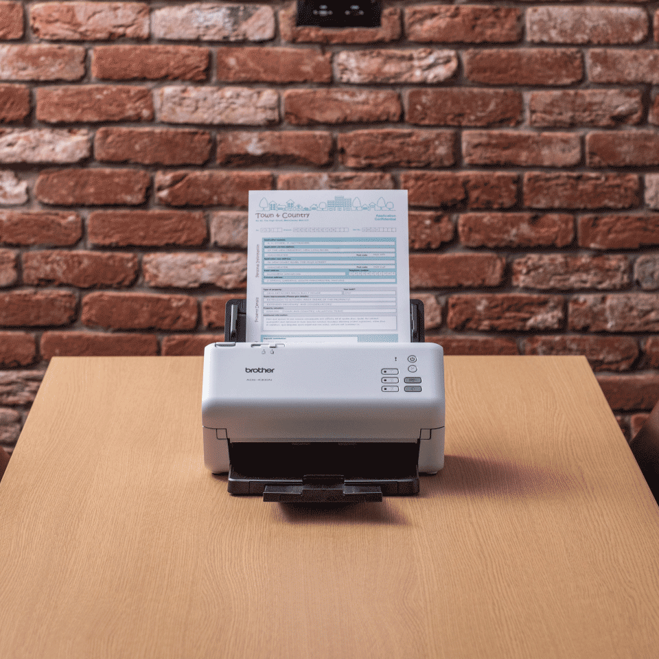 ADS-4300N on desk with document, brick wall