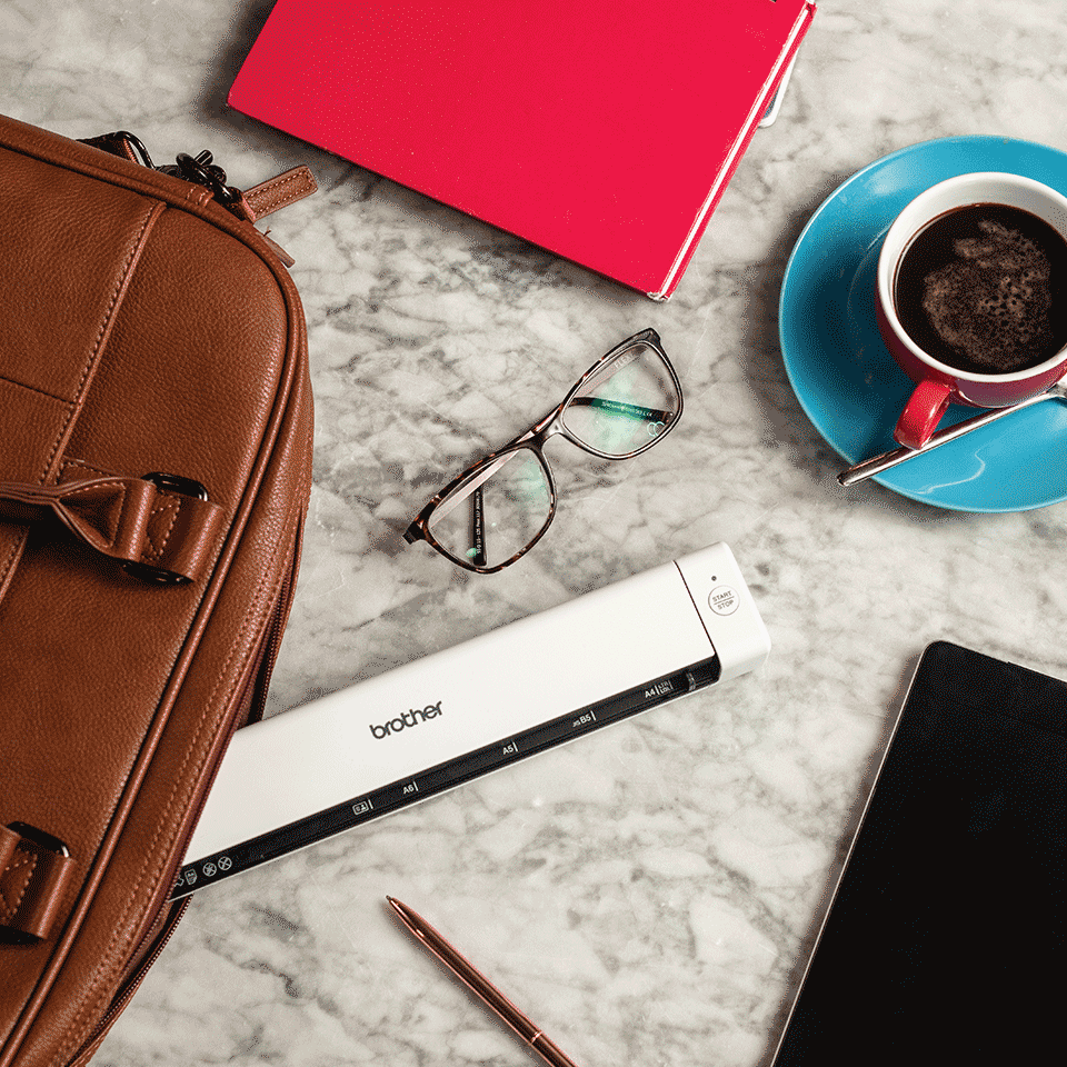DSmobile DS-640 portable scanner on marble table with glasses, pen, tablet, coffee, notebook, brown leather laptop bag
