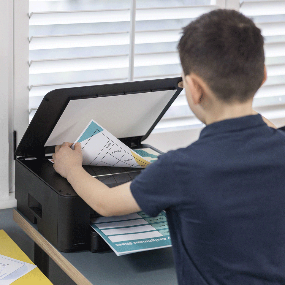 <p>Child scanning colour document from DCPT580DW flatbed</p>