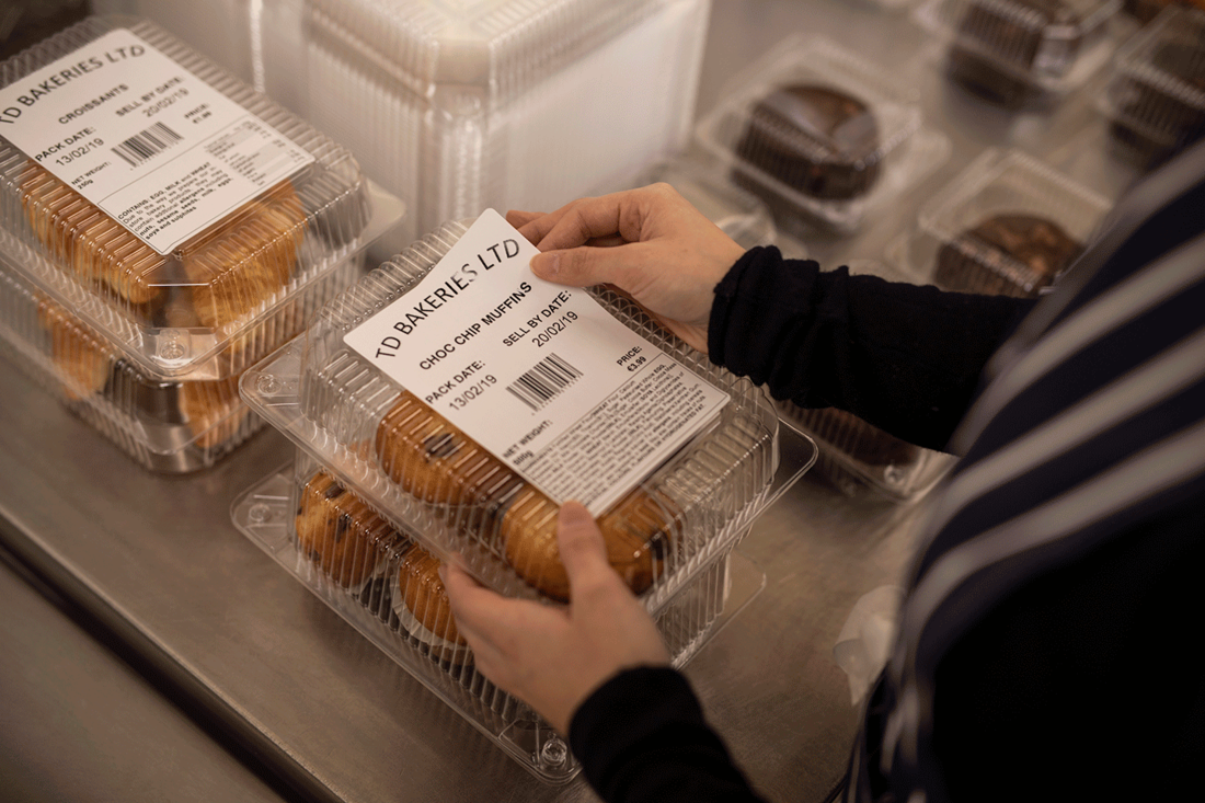 Food label being applied to cookie packaging on metal surface
