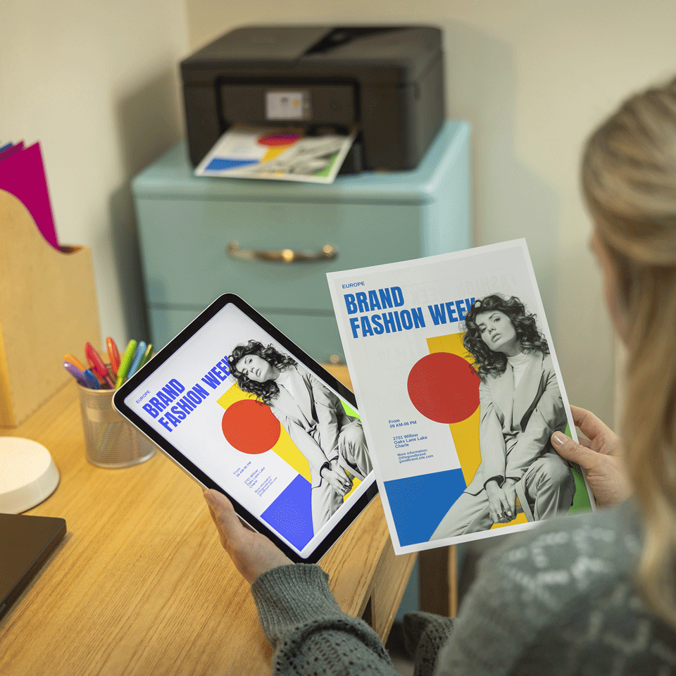 <p>Female holding printed output next to smart device to check print quality from the DCPJ1460DW</p>