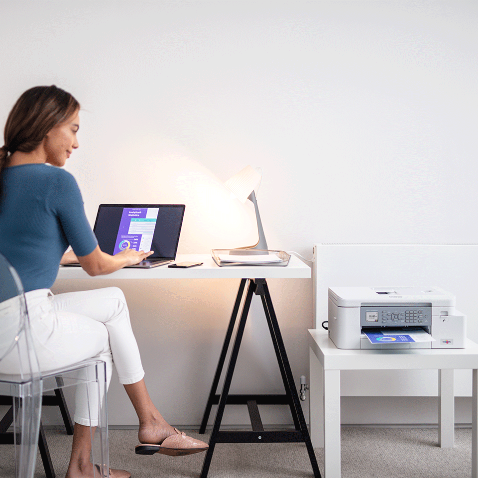 Lady working at home with MFCJ4340DW next to her workstation