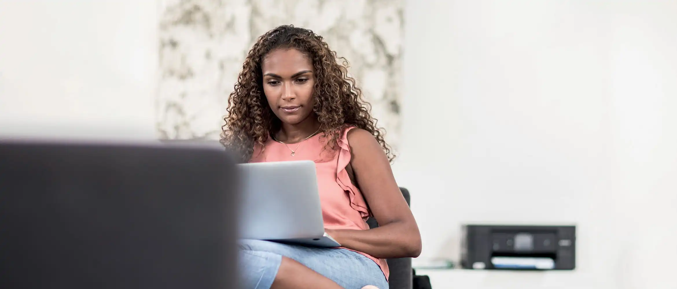 Mulher com cabelo rizadd sentado com laptop
