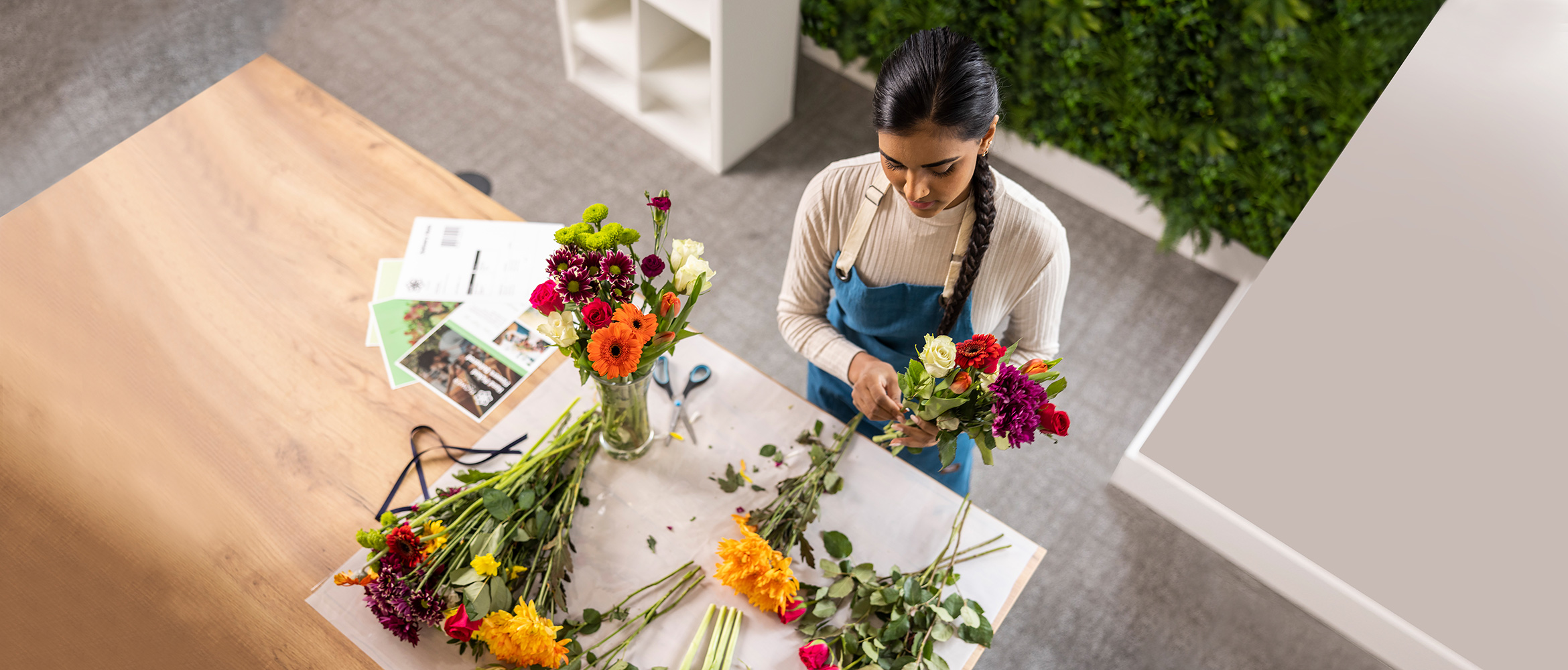 Female holding flowers, desk, colour documents