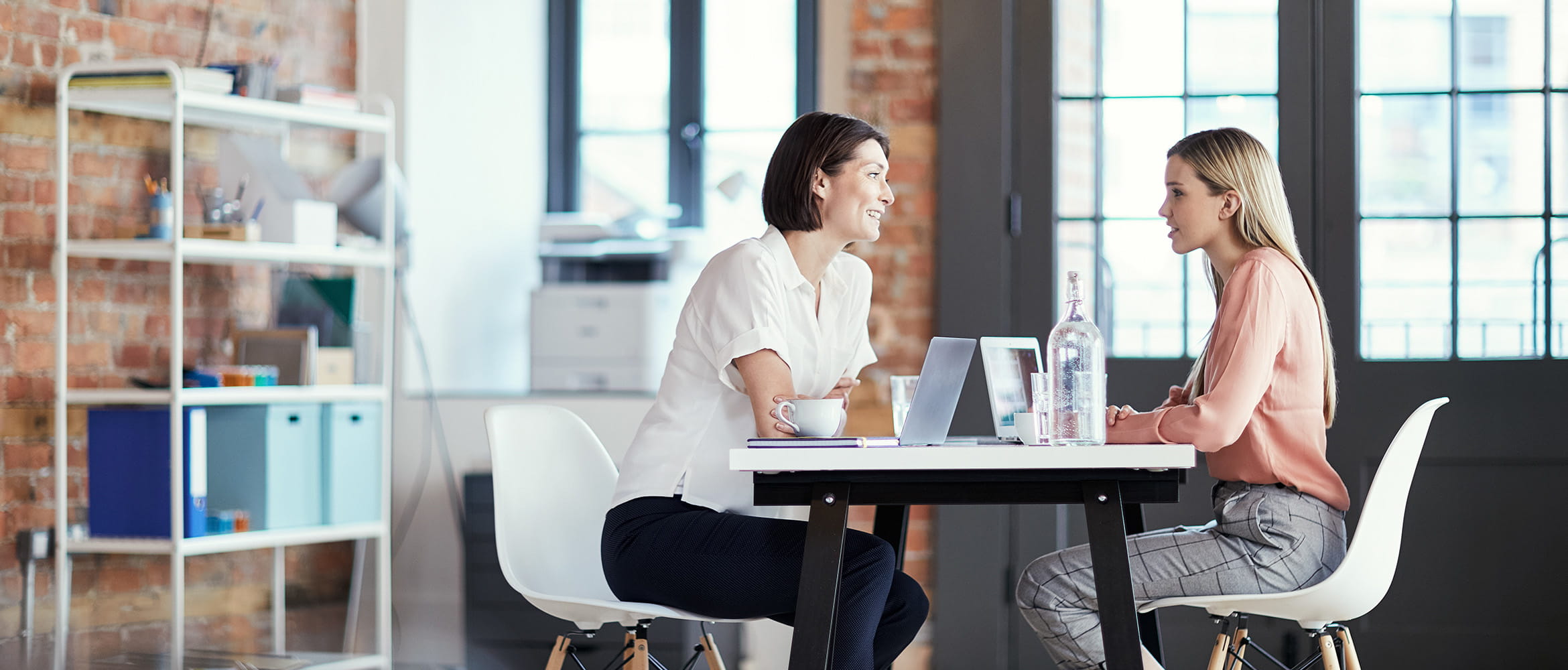 Des femmes en réunion qui parlent assise à un bureau