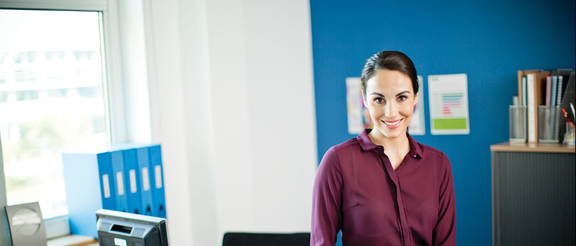 Woman in an office with various office items labelled around her