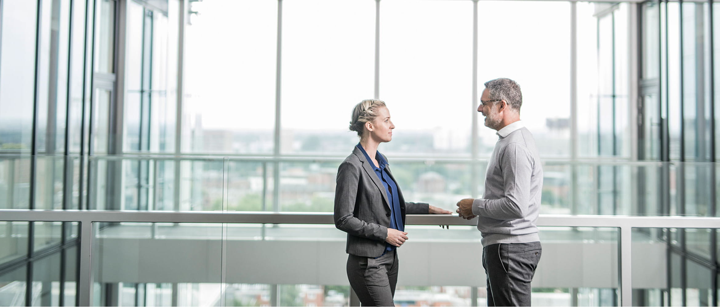 Business man and woman meeting on an office balcony