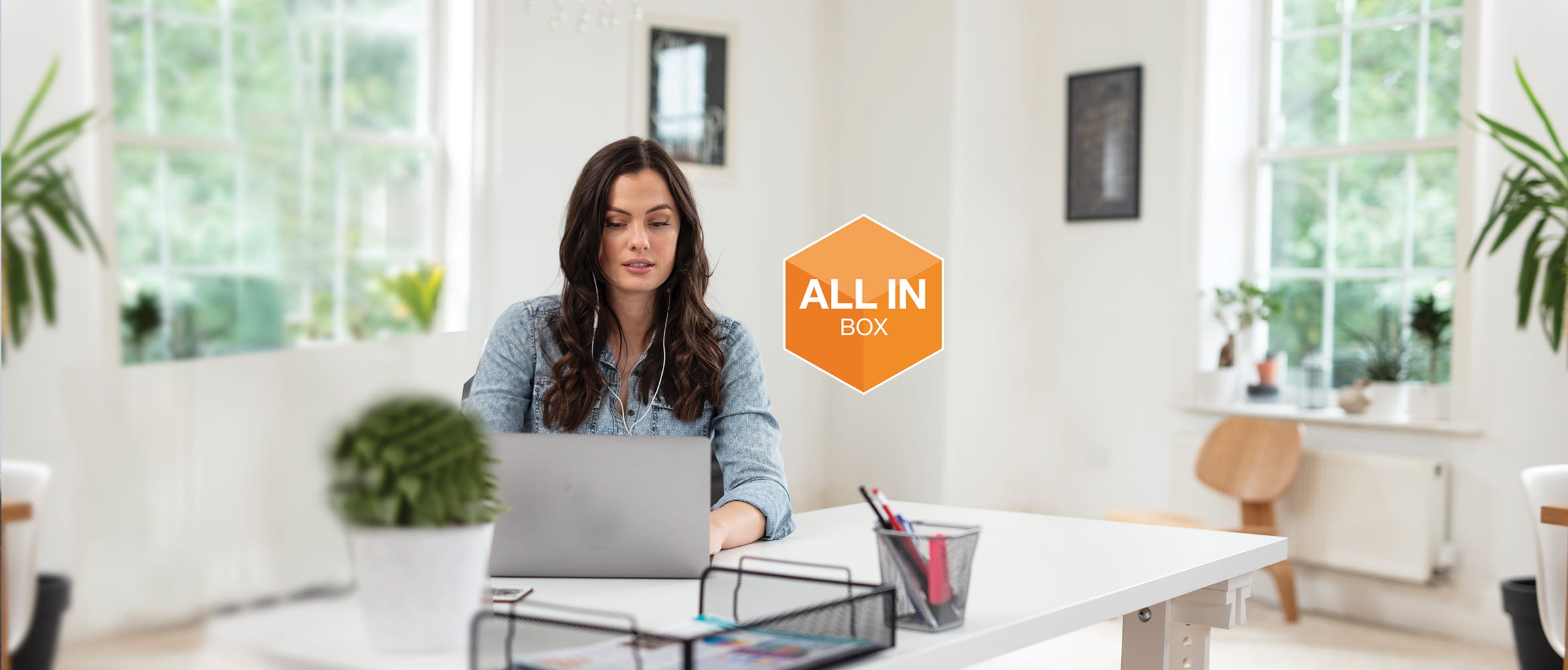 Femme assise au son pc avec logo All in Box