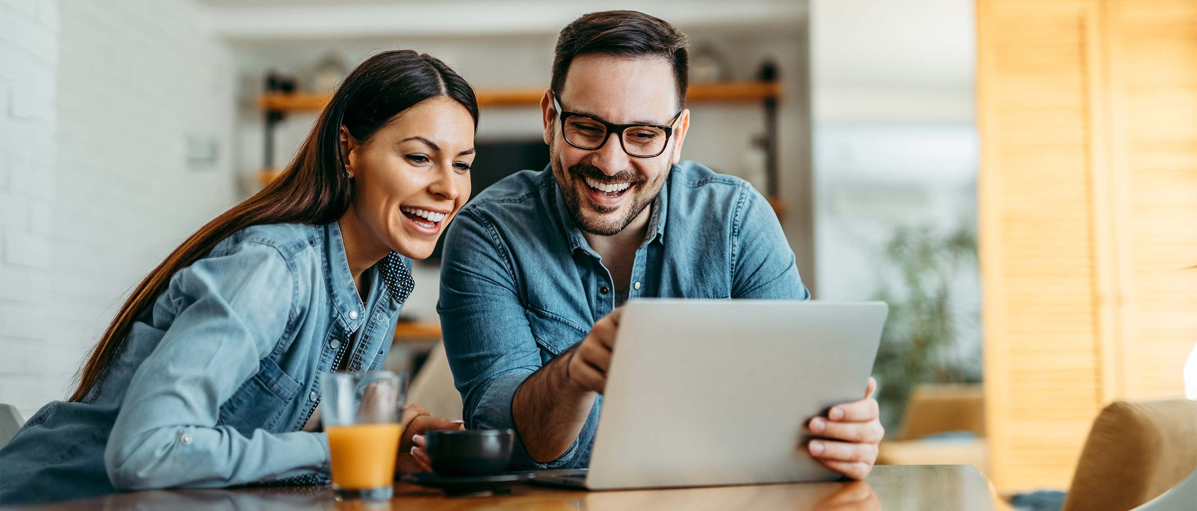 un couple regardant les promotions Brother sur leur ordinateurs portables