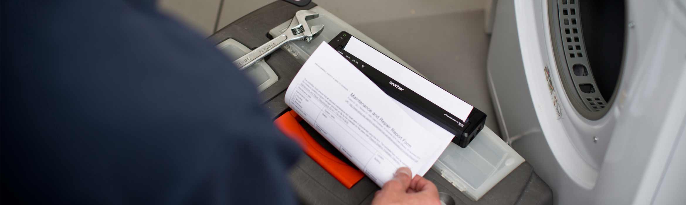 Man fixing a washing machine and printing the invoice using a Brother PJ printer