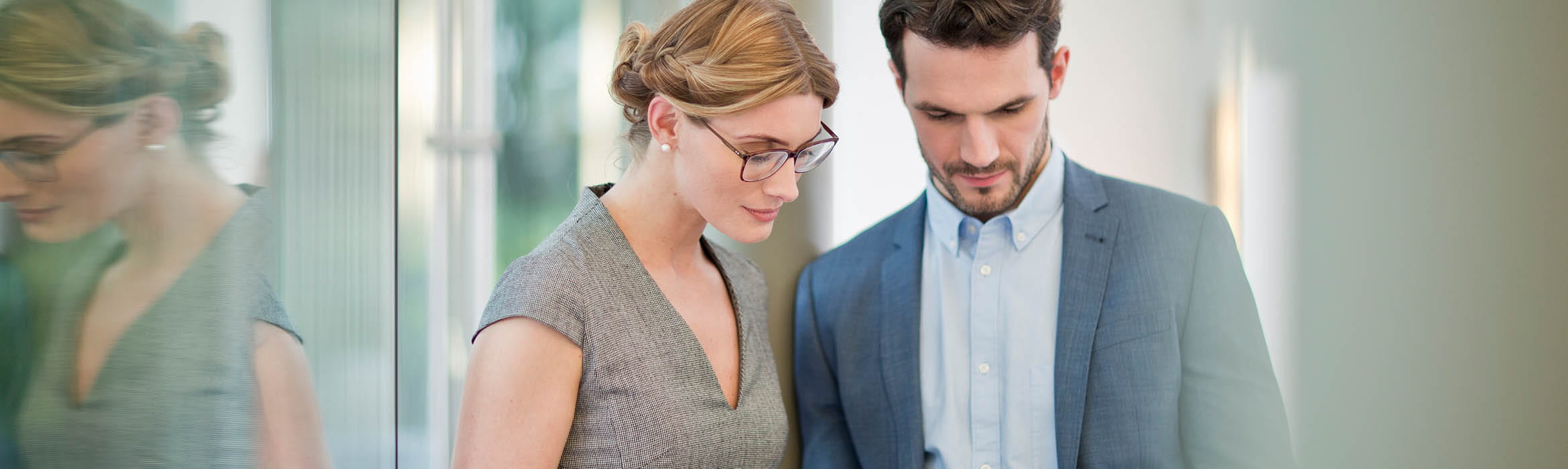 two colleagues view a tablet device