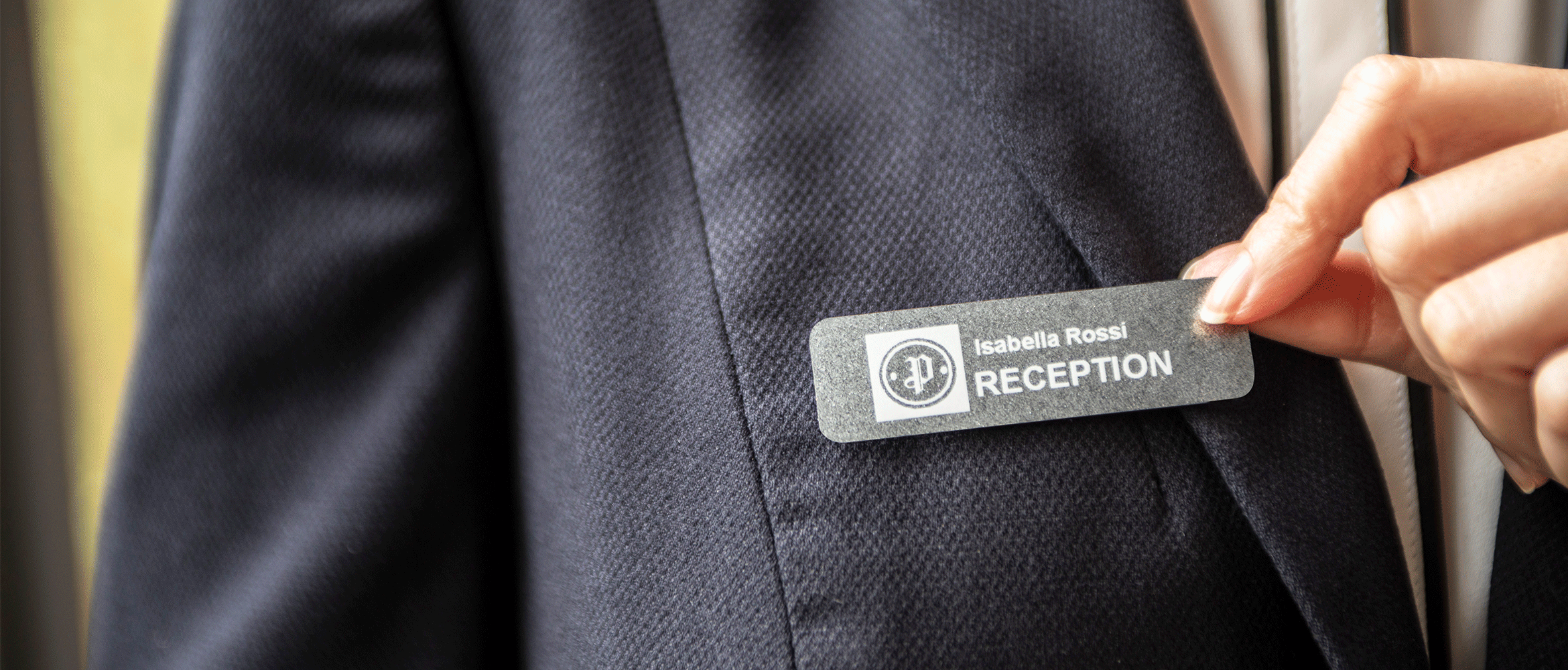 Receptionist wearing name badge made from Brother device