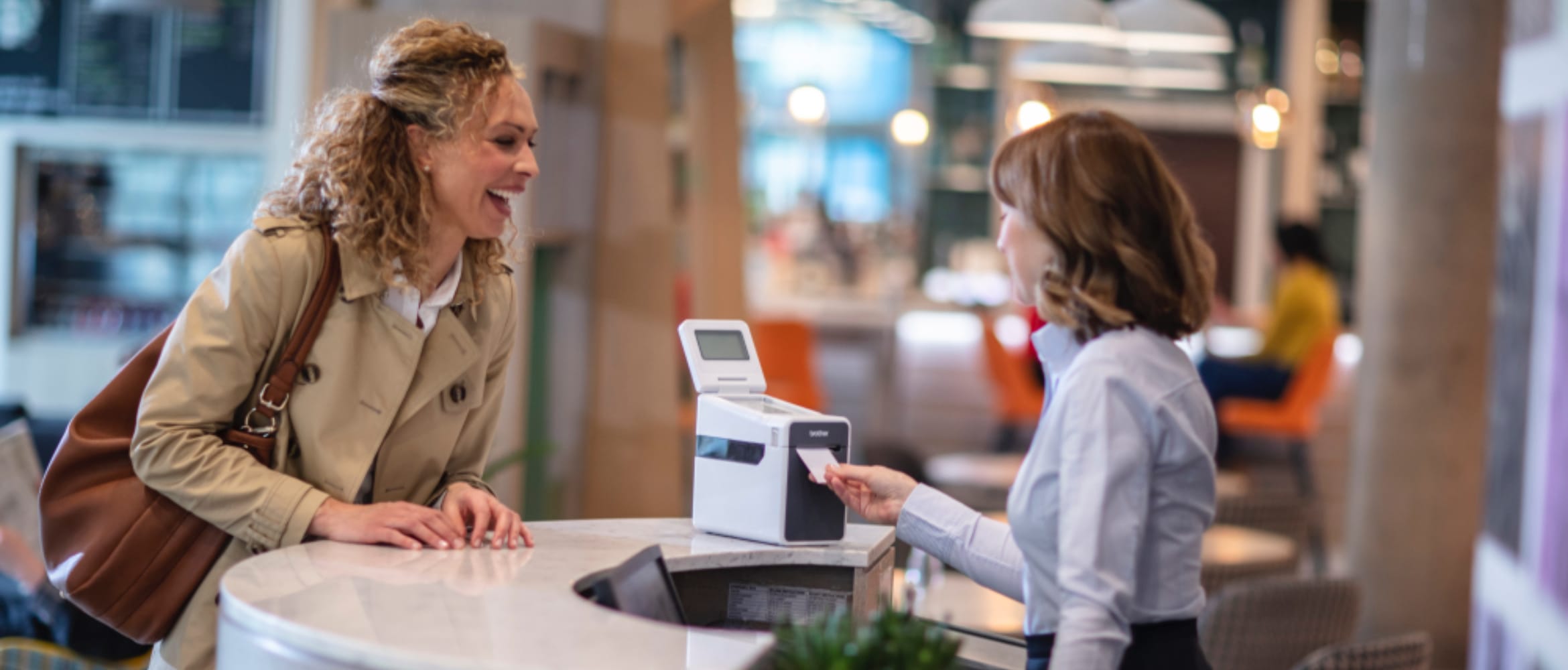 Female sales assistant serving woman at retail checkout