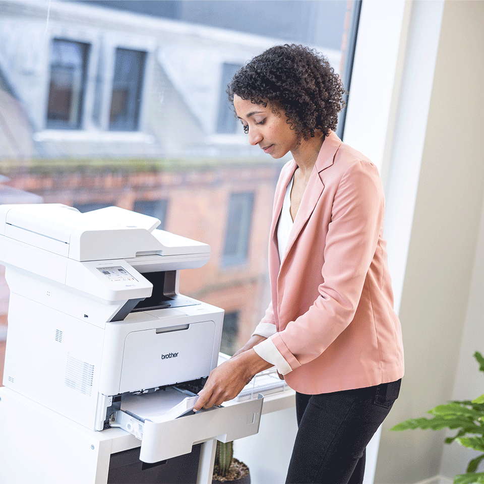 Woman wearing pink jacket, opening paper tray on Brother MFC-L5710DW