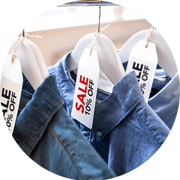 Red and black sale labels on hangers holding denim shirts