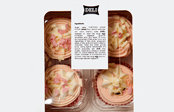 Pink and white cupcakes in a white and clear plastic box with a ingredient label