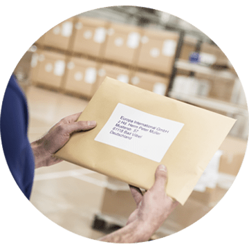 a warehouse employee holding an envelope with a printed label