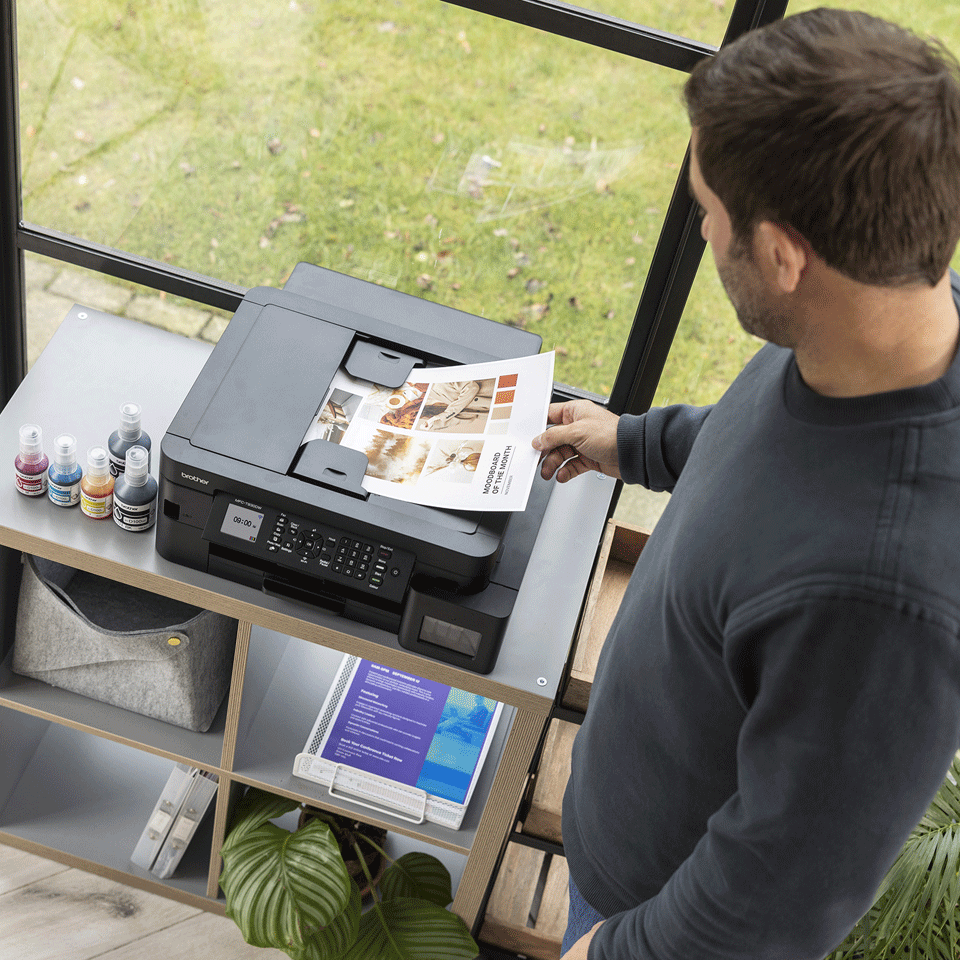 <p>Man removing colour output from MFCT930DW ADF</p>