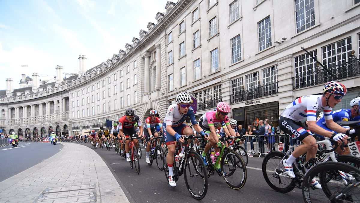 Racing cyclists, city backdrop