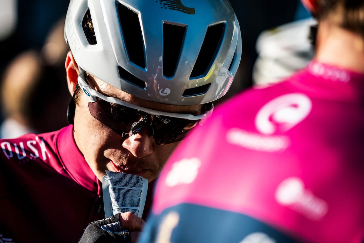 Jake Womersley taking on sustenance amongst other cyclists at a race