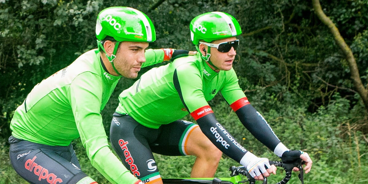 cycling teammates cycle with arms around each other