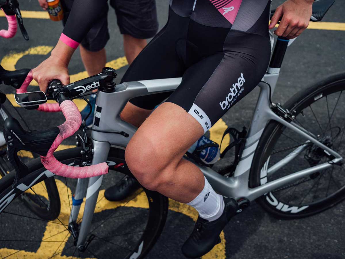 Leah Dixon sits on bike in Brother UK cycling kit