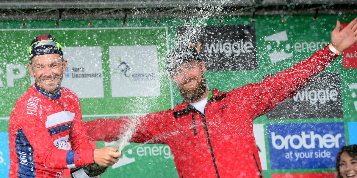 cyclist celebrates victory with champagne on the podium
