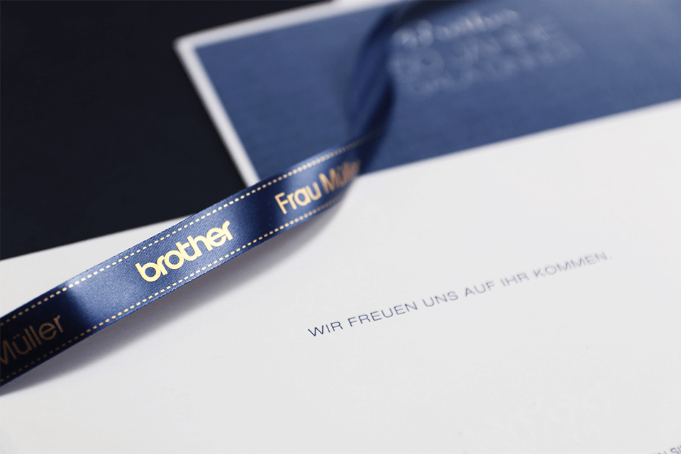 Brother TZe-RN34 satin ribbon tape cassette - gold on navy blue - welcome envelope with a company logo printed onto a personalised ribbon