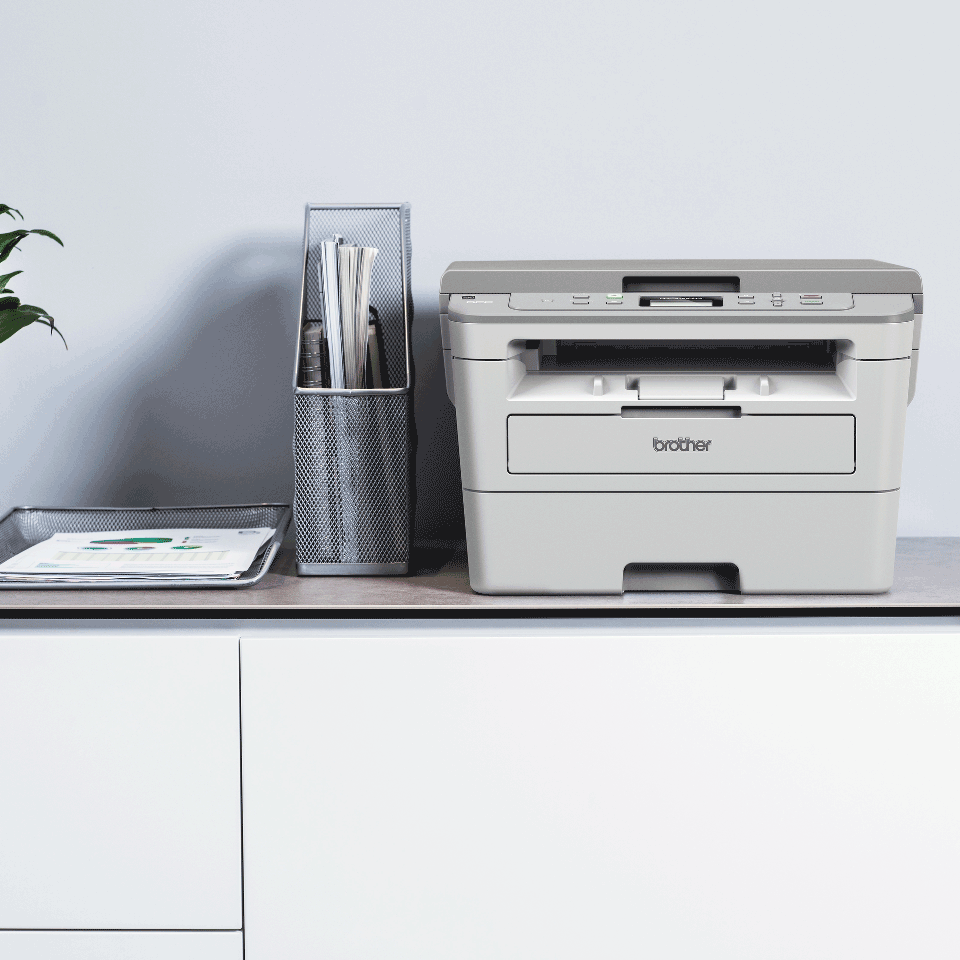 Brother DCP-B7520DW  mono laser 3-in-1 printer on a white cabinet