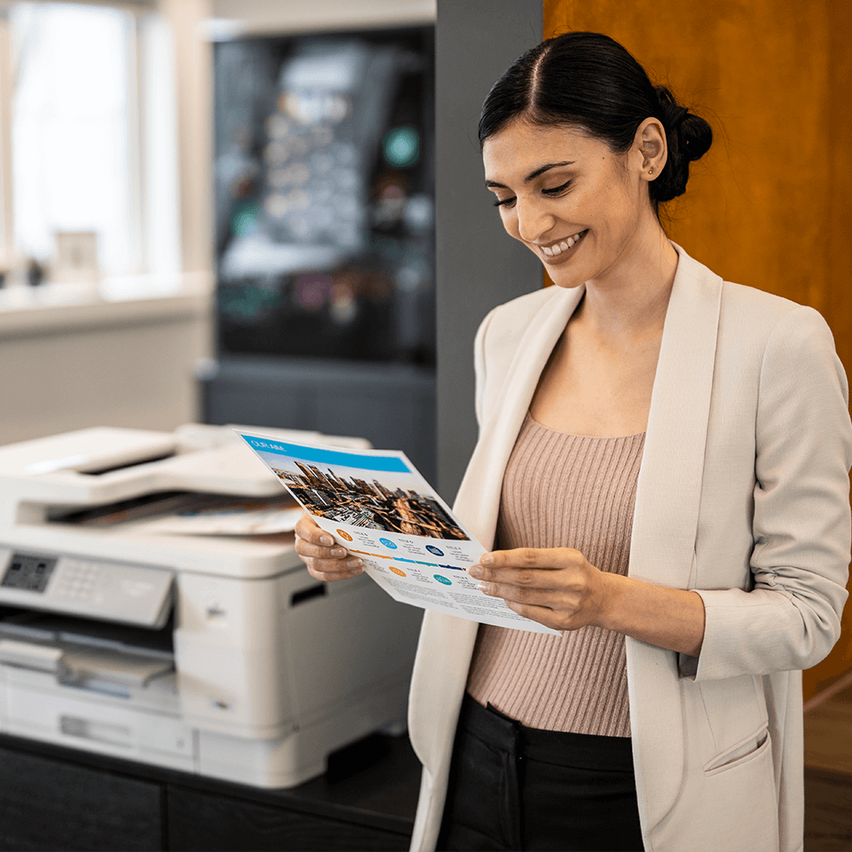 Female holding colour document in office next to printer