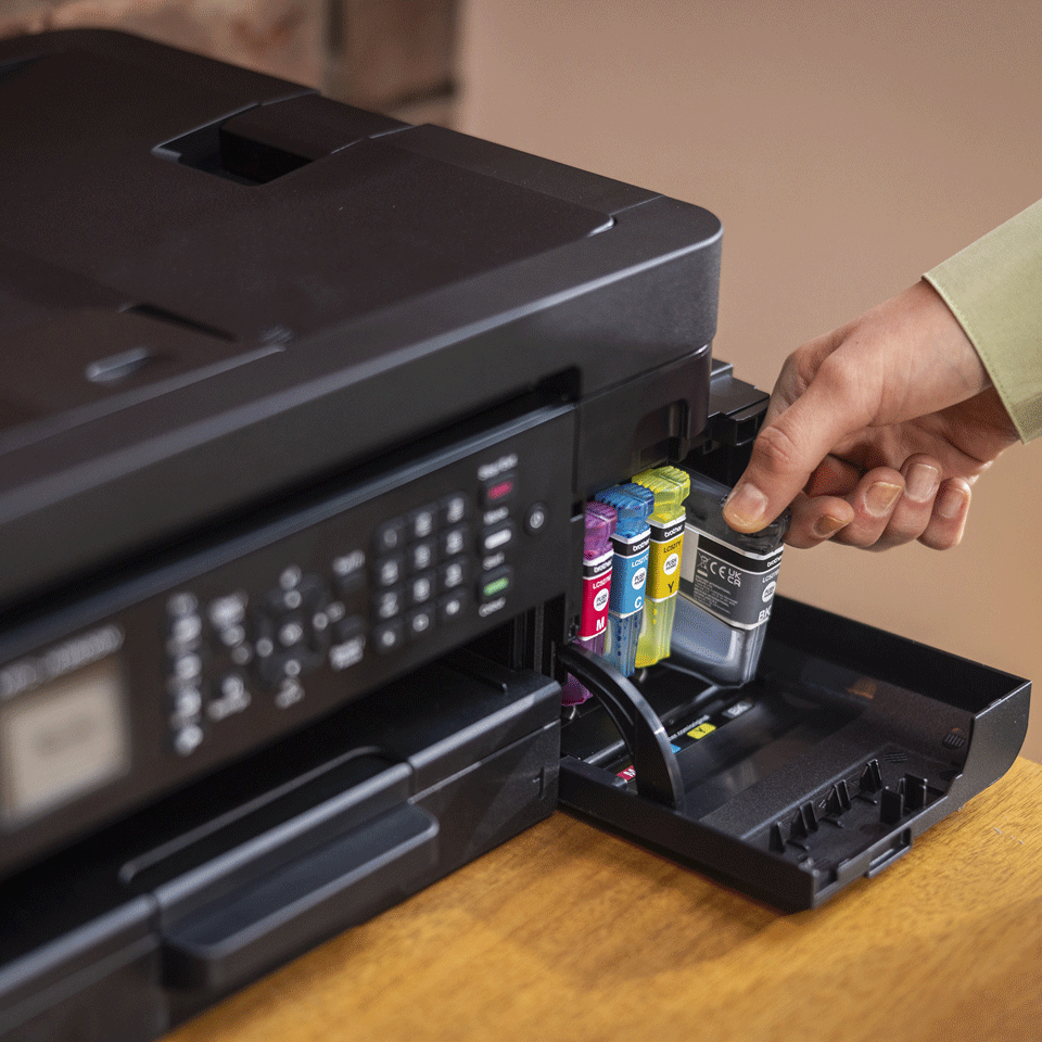 <p>LC527 black cartridge being inserted into inkjet printer</p>