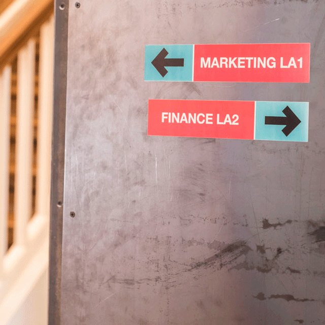 Signs inside building showing directions to marketing and finance departments (printed on 50mm CZ-1005 full colour label roll)