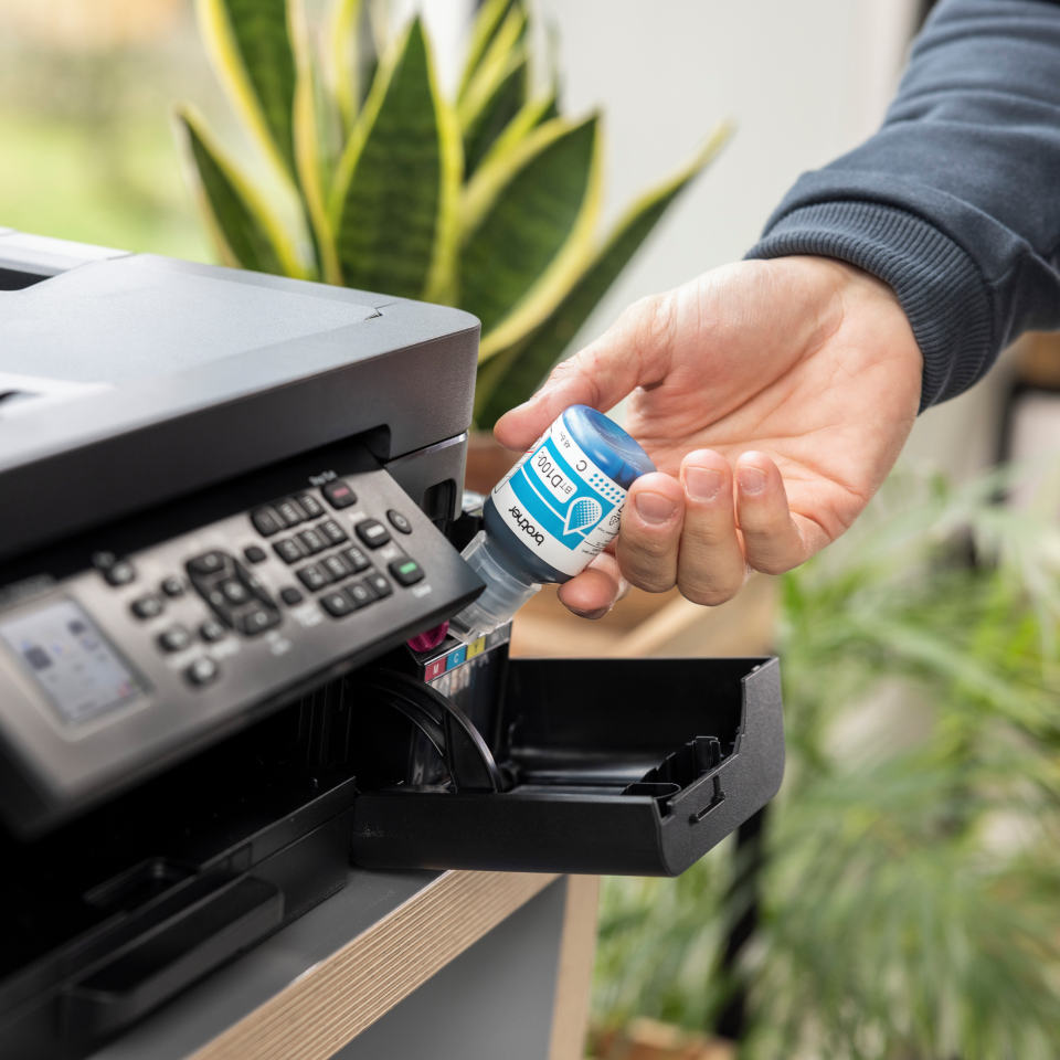 <p>Brother inkjet machine being filled using BTD100C cyan ink bottle</p>