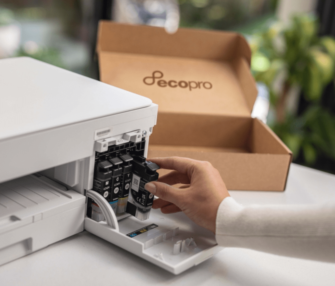 Woman replacing printer cartridge on printer with a brown box on the table