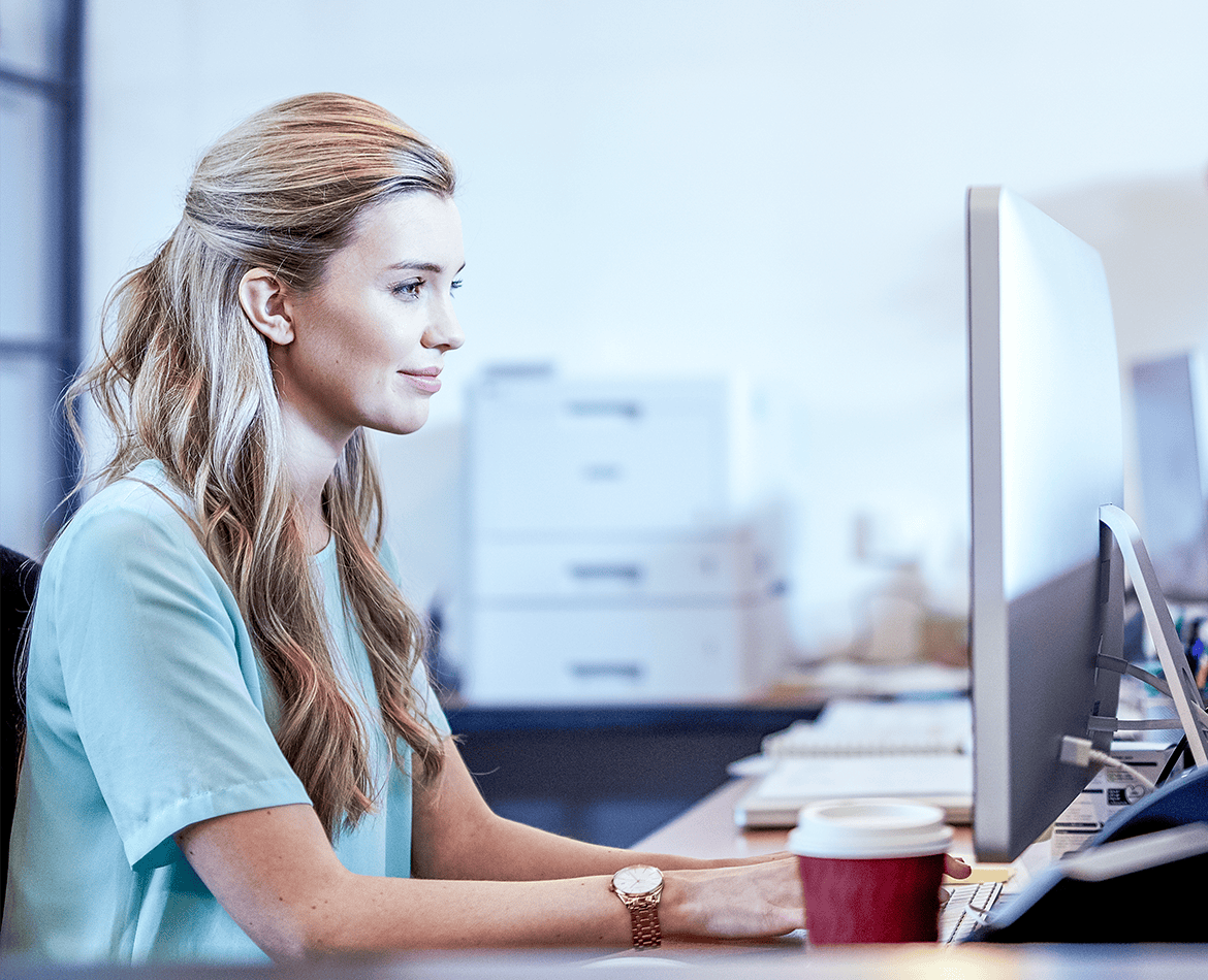 Side view of a woman using a desktop computer in an office environment