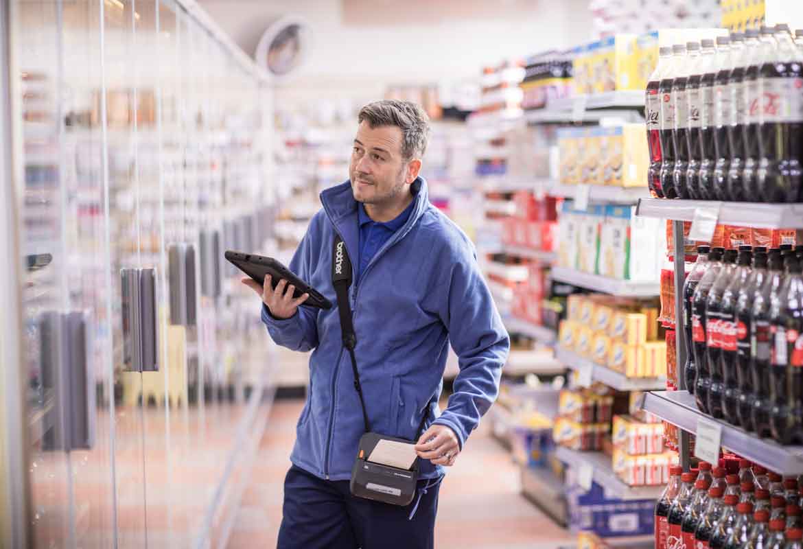 Man with a portable Brother printer, printing a receipt in a supermarket