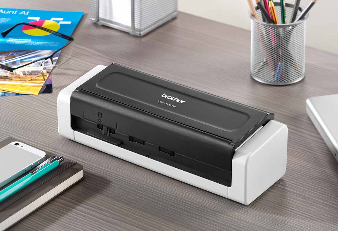 Brother ADS-1700W compact document scanner closed on grey desk