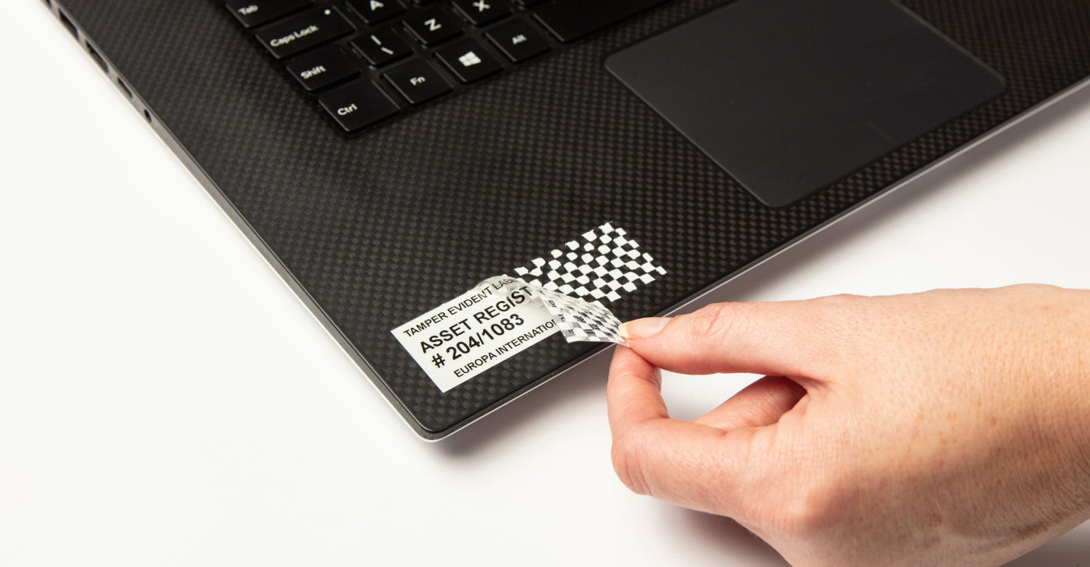 Cinta laminada de seguridad Brother despegándose de portátil