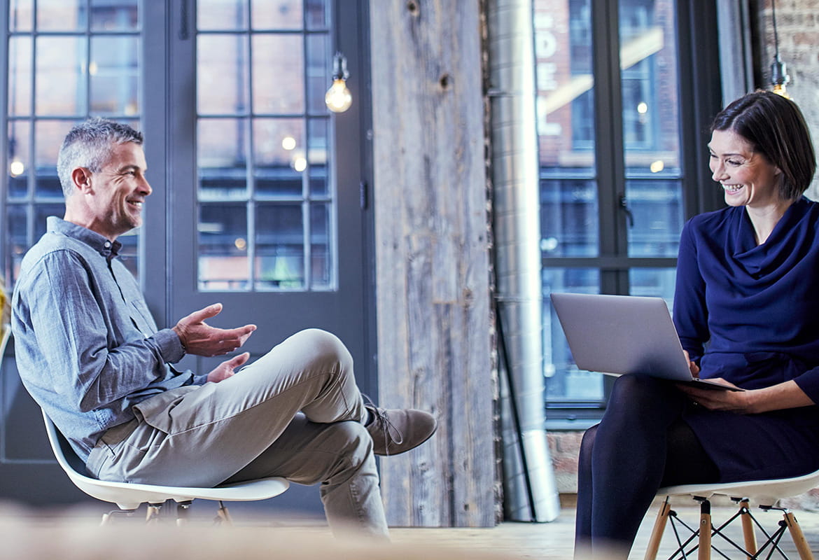 A business man and woman sat down talking