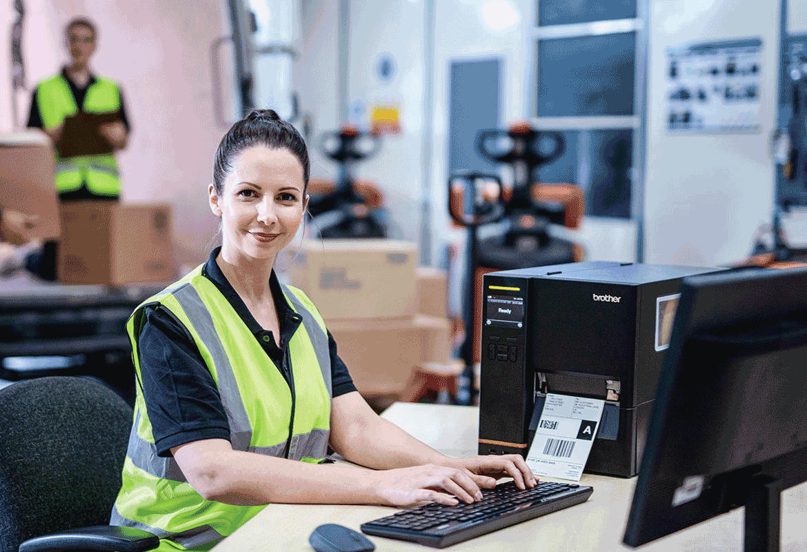 female employee using a brother TJ industrial label printer in a warehouse setting