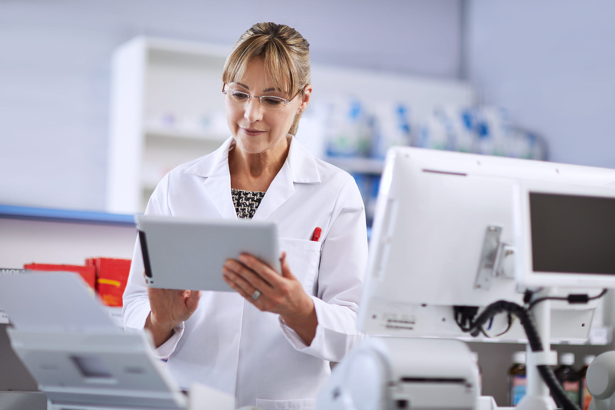 A Brother mobile scanner on a hospital counter scanning a medical test report while a doctor is reading patient notes