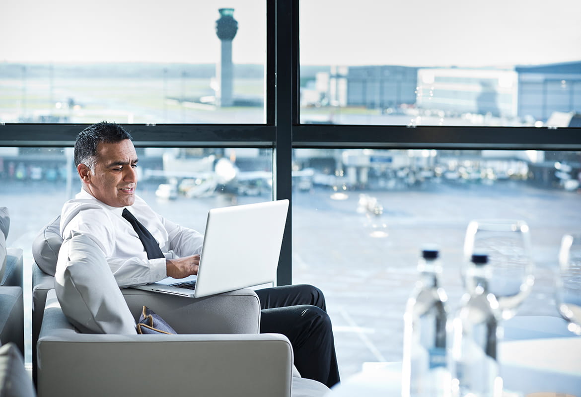 Businessman using a laptop computer in the departure lounge at an airport