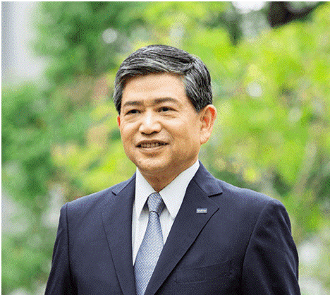 Ichiro Sasaki - Director and President of Brother Industries Ltd Japan - is pictured in a business suit and tie against a green environmental background in this corporate portrait headshot