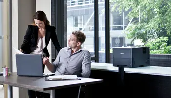 Businessman and businesswoman looking at a document in a office