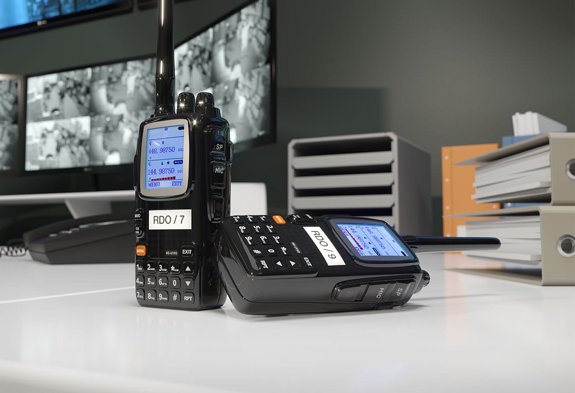 Walkie talkie on table with identification label, monitors, files in background