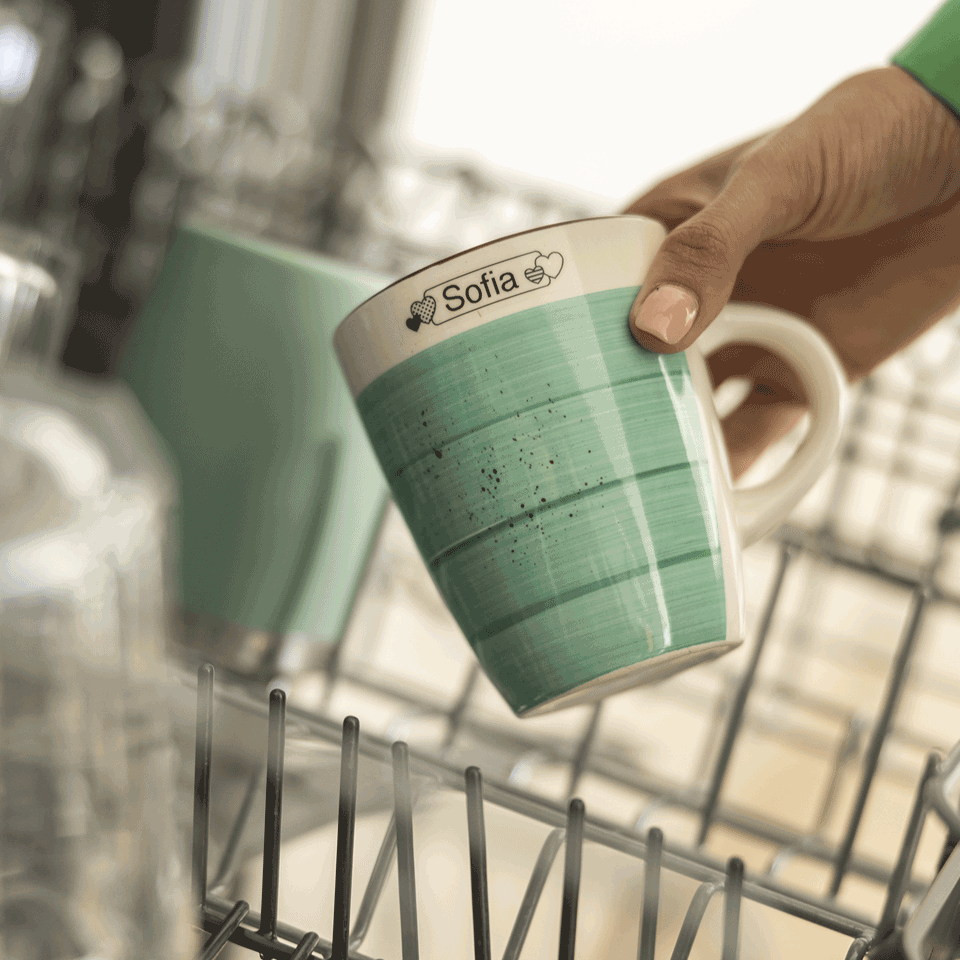 <p>mug with name tag label being placed in dishwasher using Btag-231 Black on White 12mm tape&nbsp;</p>