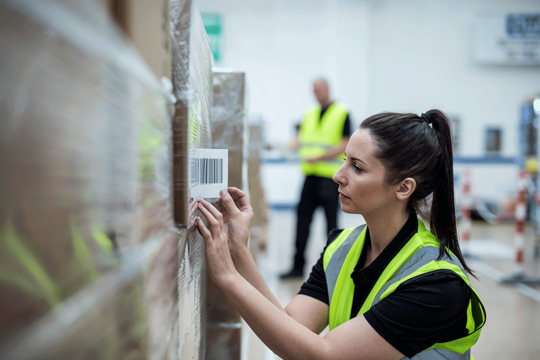 Woman in high visibility vest labelling pallet