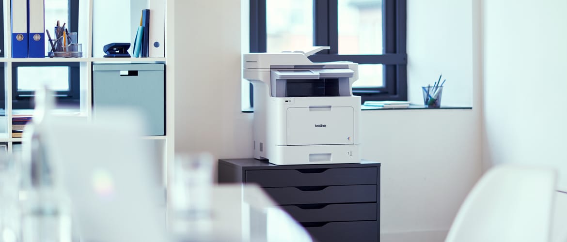 Brother printer on a chest of drawers in an office environment