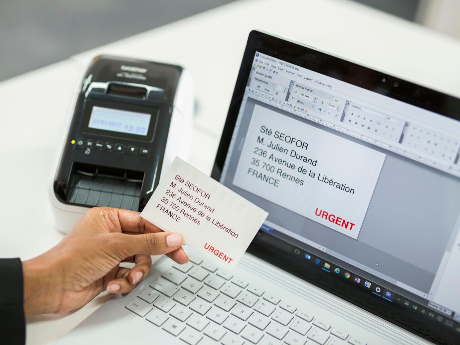 Impresora de etiquetas QL-810W Brother junto a impresora portátil